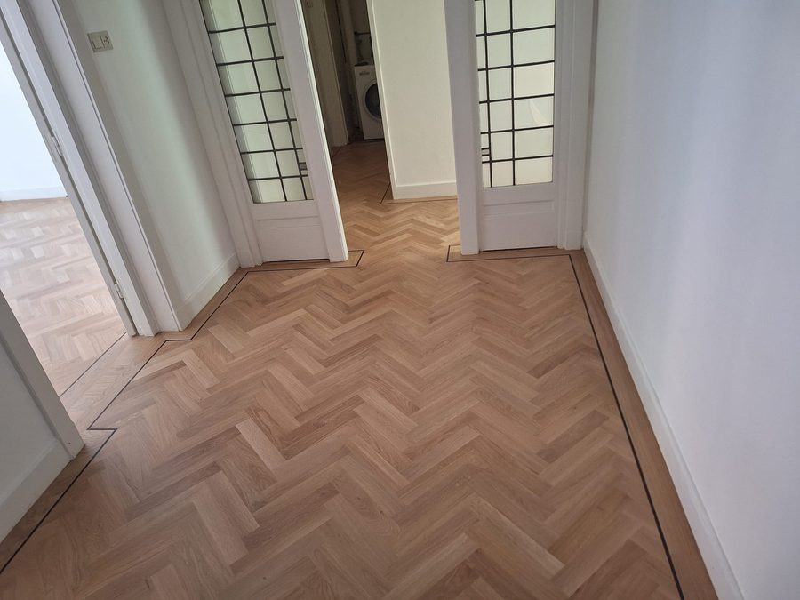 Eiken tapis visgraat met bies, doorlopend door meerdere kamers