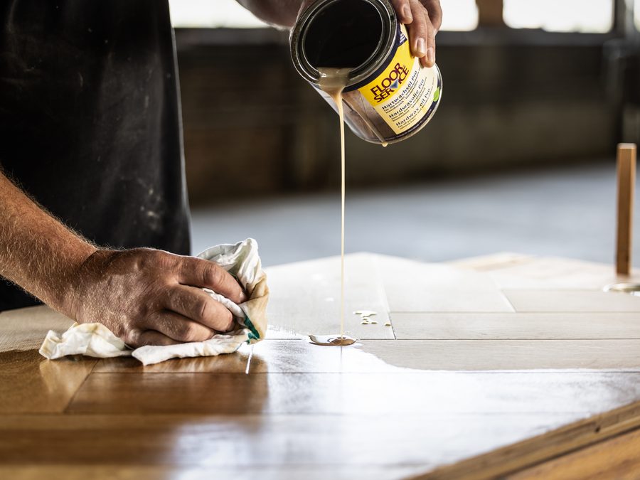 Hardwasolie wordt op een houten vloer aangebracht