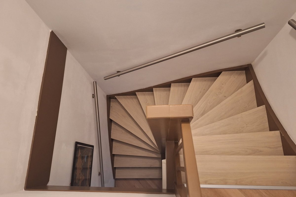 Gerenoveerde trap met bordes in een lichte hal