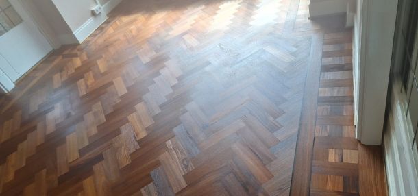 Warme teak visgraatvloer na het schuren en oliën