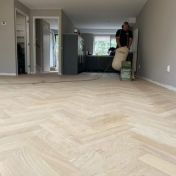 Lichte eiken visgraatvloer in een woonkamer